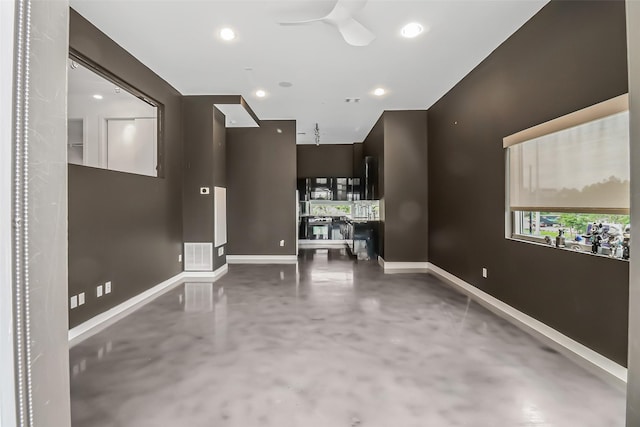 interior space with visible vents, concrete flooring, baseboards, ceiling fan, and recessed lighting
