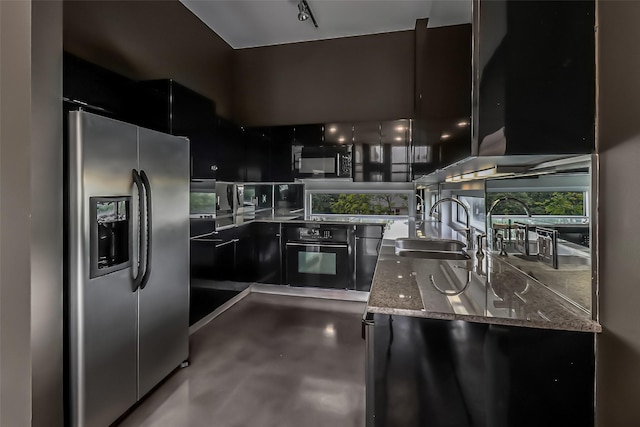 102 Quitman St Unit 301, Houston, TX 77009 - kitchen featuring black appliances, dark cabinets, a sink, light stone counters, and modern cabinets