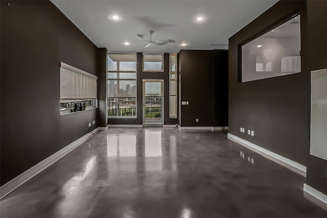 empty room with a ceiling fan, baseboards, concrete flooring, and recessed lighting