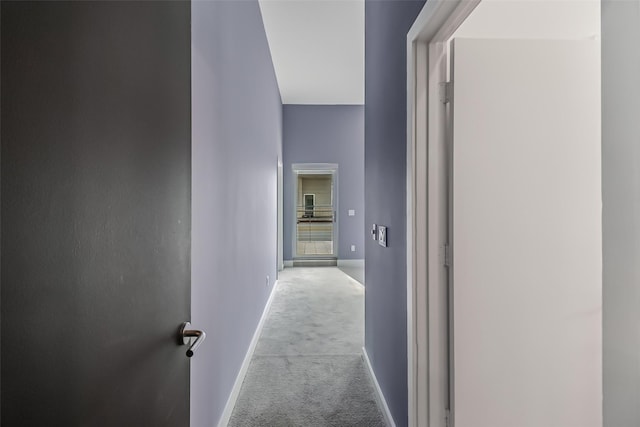 hallway with carpet floors and baseboards