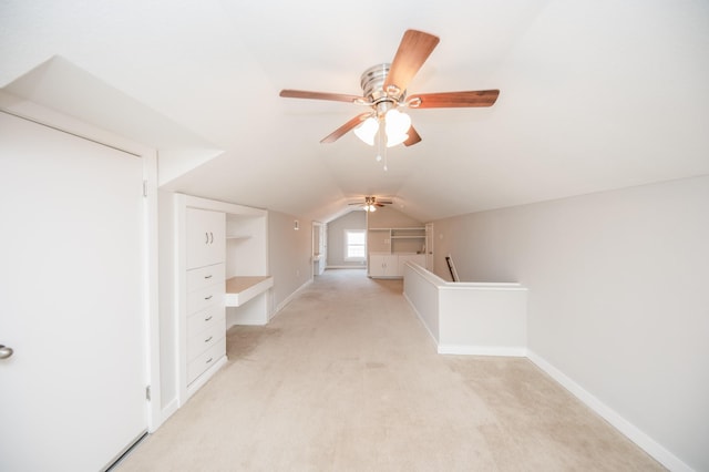bonus room with baseboards, vaulted ceiling, light carpet, and ceiling fan