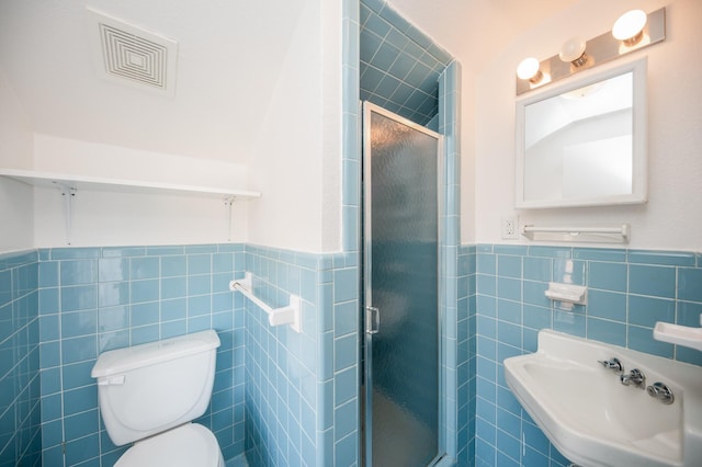 bathroom with visible vents, wainscoting, toilet, tile walls, and a shower stall