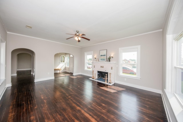 unfurnished living room with arched walkways, a ceiling fan, wood finished floors, and a fireplace