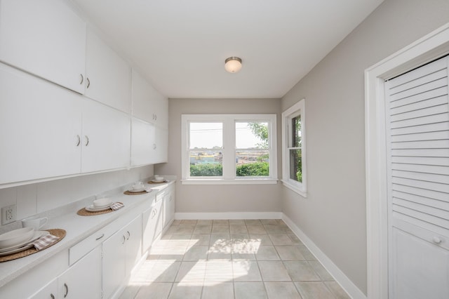 interior space featuring baseboards and light tile patterned flooring