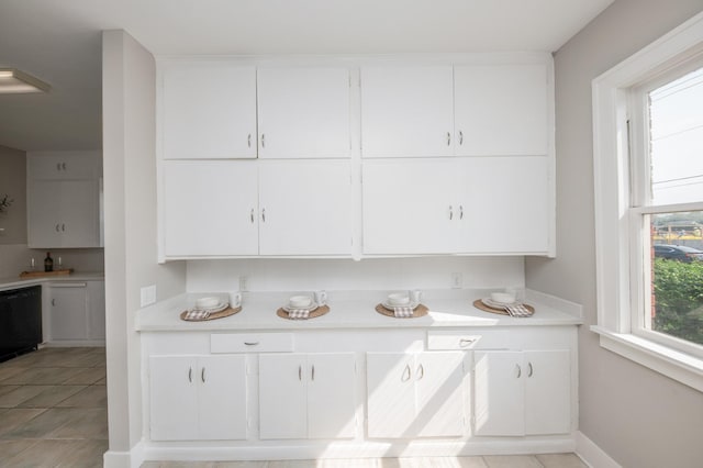 kitchen featuring light countertops, baseboards, white cabinetry, and dishwasher