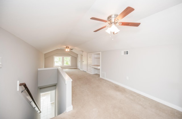 bonus room featuring a ceiling fan, visible vents, baseboards, lofted ceiling, and light carpet