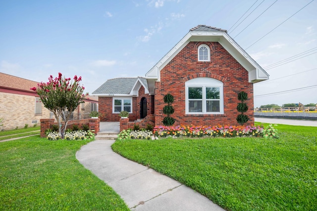 traditional home featuring a front lawn and brick siding