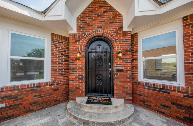 doorway to property with brick siding