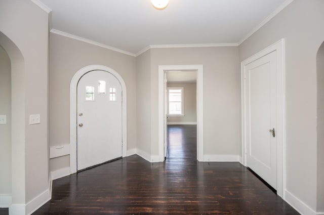 entrance foyer featuring arched walkways, ornamental molding, and wood-type flooring