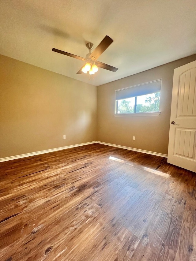 empty room featuring a ceiling fan, baseboards, and wood finished floors