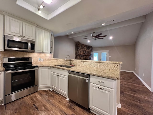 kitchen with dark wood-style flooring, tasteful backsplash, a sink, a peninsula, and stainless steel appliances