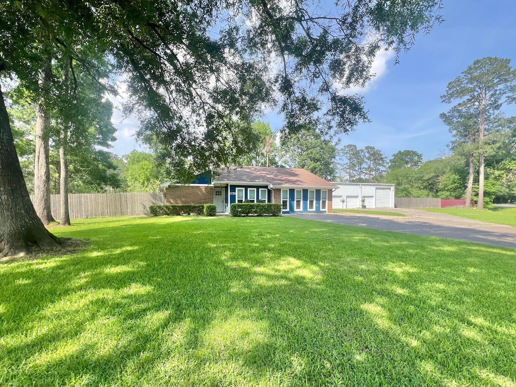 1725 S Timberlane St, Vidor, TX 77662 - single story home featuring fence, a front yard, and a detached garage
