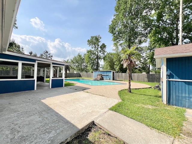 view of swimming pool featuring a shed, a fenced backyard, a fenced in pool, an outbuilding, and a patio
