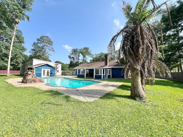 view of swimming pool with a fenced in pool, an outdoor structure, a fenced backyard, and a yard