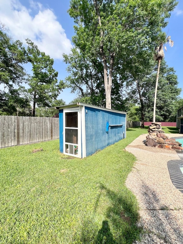 view of outdoor structure featuring fence and an outbuilding