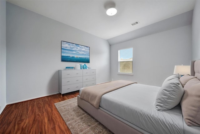bedroom featuring visible vents, lofted ceiling, and wood finished floors