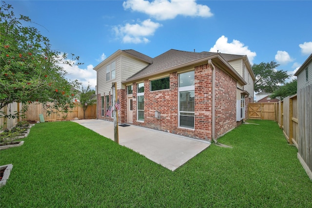 back of house featuring brick siding, a fenced backyard, a patio area, and a lawn