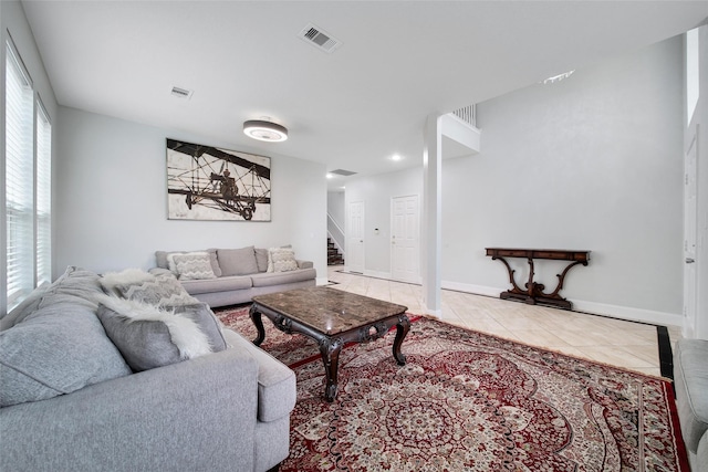 living room featuring stairway, tile patterned floors, a wealth of natural light, and visible vents