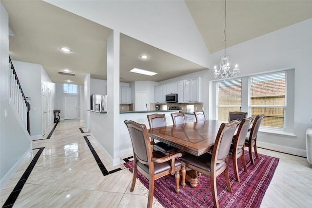 dining area featuring baseboards, plenty of natural light, a notable chandelier, and stairway
