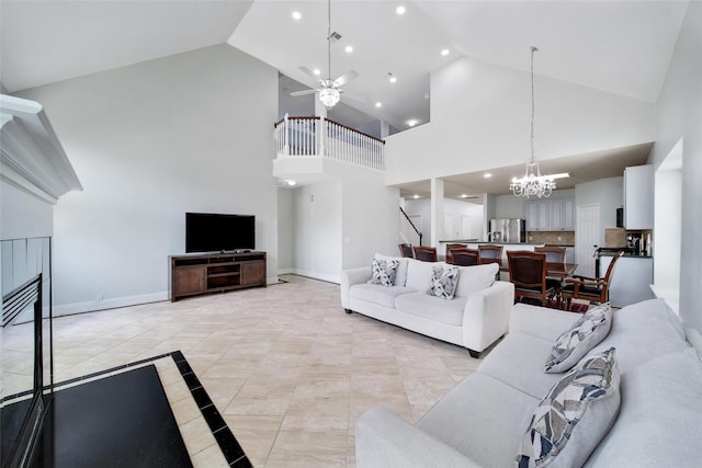 living room featuring high vaulted ceiling, ceiling fan with notable chandelier, stairs, recessed lighting, and baseboards