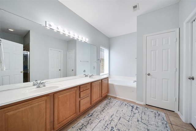 full bathroom with double vanity, a garden tub, visible vents, tile patterned flooring, and a sink