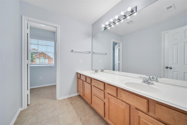 bathroom with a sink, tile patterned floors, double vanity, and visible vents