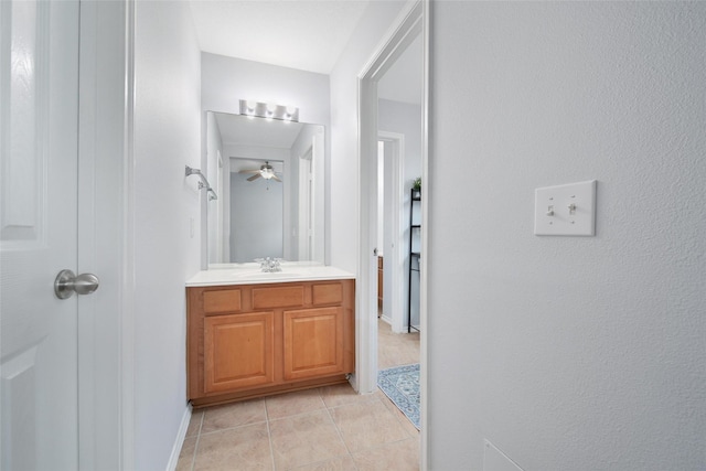 bathroom featuring tile patterned flooring, baseboards, ceiling fan, and vanity