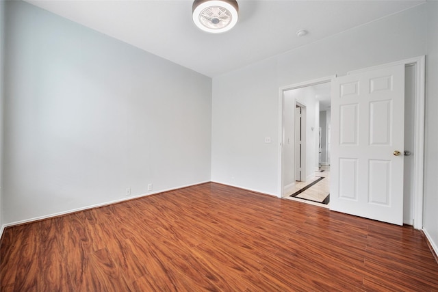 empty room with baseboards and wood finished floors