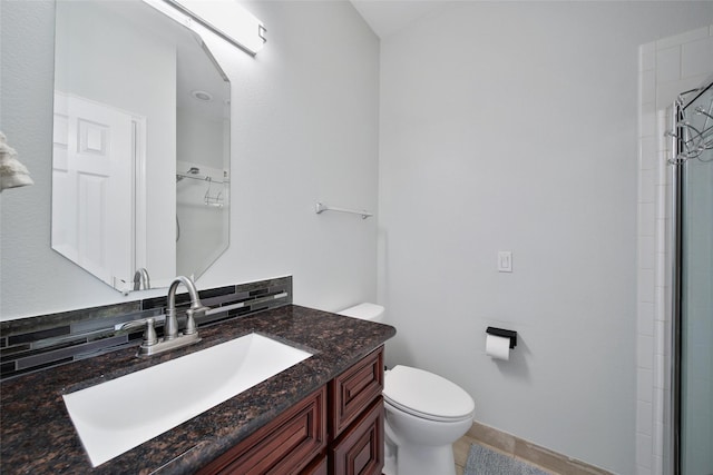 full bathroom featuring vanity, toilet, and tiled shower