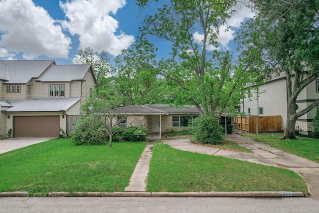 view of front facade featuring metal roof, a front yard, a garage, fence, and concrete driveway