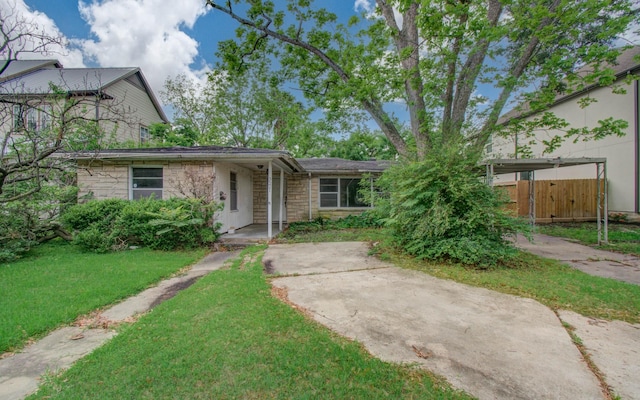 view of front of house with fence, a carport, a front lawn, and stone siding