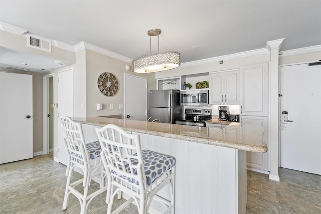 kitchen featuring crown molding, a breakfast bar, stainless steel appliances, a peninsula, and visible vents
