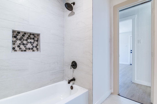 bathroom featuring baseboards and shower / bathing tub combination