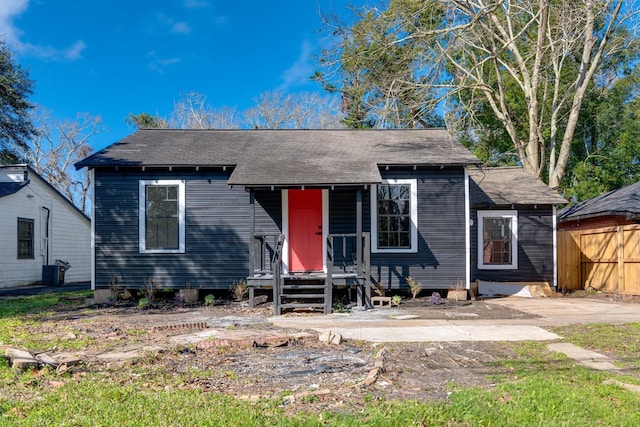 bungalow featuring cooling unit and a shingled roof