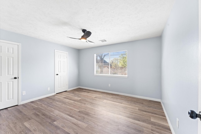 4103 Waterstone Dr, Missouri City, TX 77459 - unfurnished bedroom featuring baseboards, a textured ceiling, wood finished floors, and visible vents