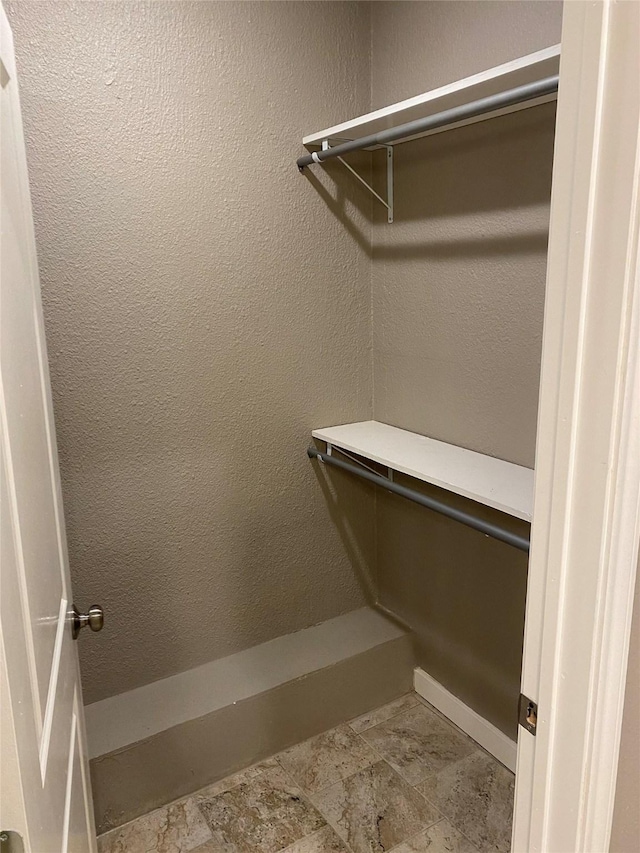 spacious closet featuring stone finish floor