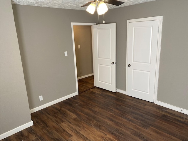 unfurnished bedroom with baseboards, ceiling fan, and dark wood-type flooring