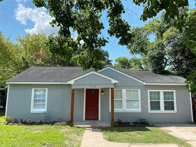 ranch-style house with a shingled roof and a front yard