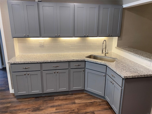 kitchen with a sink, tasteful backsplash, and gray cabinetry