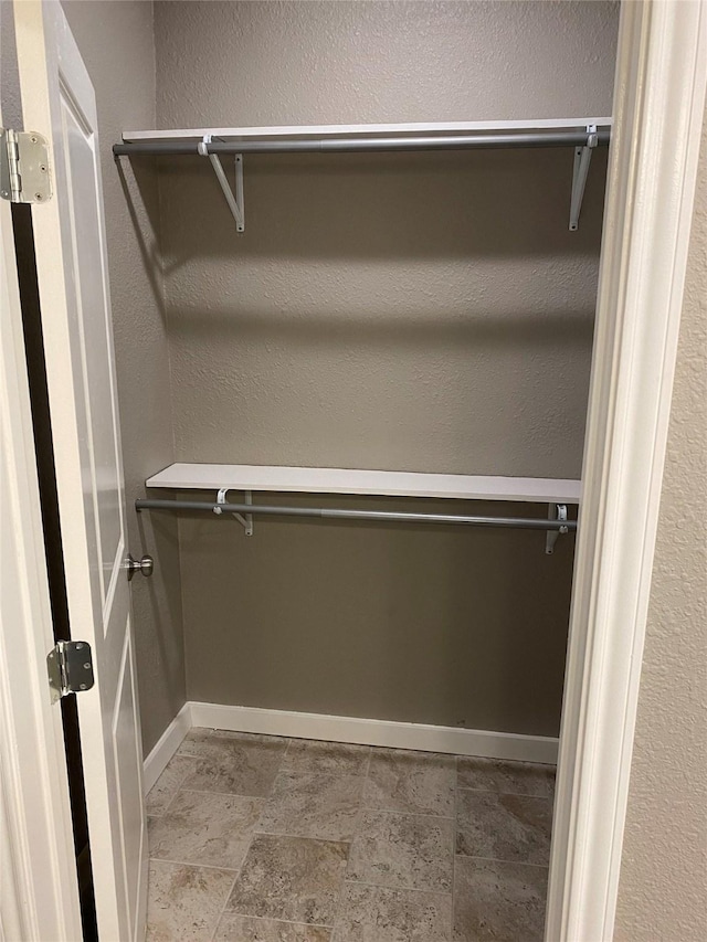 spacious closet with stone finish flooring