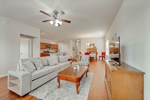 7908 Beryl Ct, Texas City, TX 77591 - living room with baseboards, light wood finished floors, and ceiling fan with notable chandelier