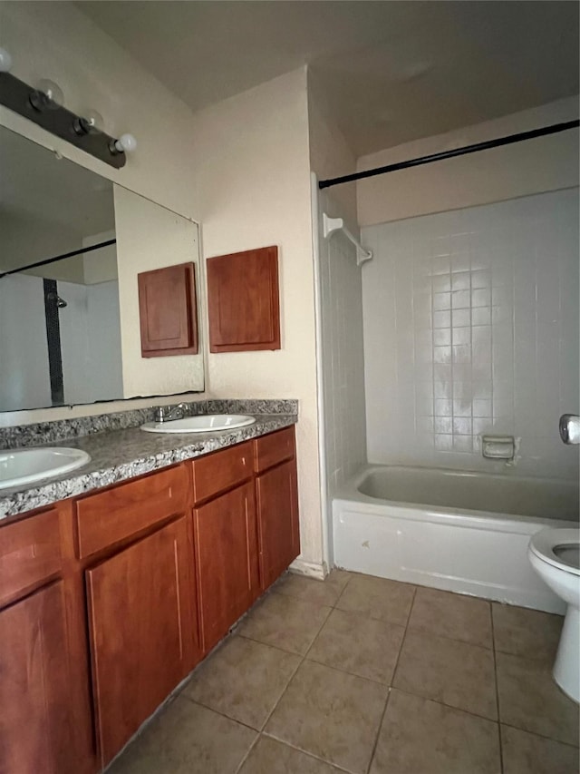 full bathroom with double vanity, tile patterned floors, and a sink