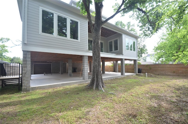 back of house with fence, a patio, and a yard