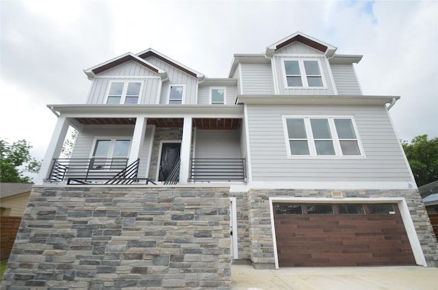 craftsman-style house featuring a garage, board and batten siding, driveway, and stone siding