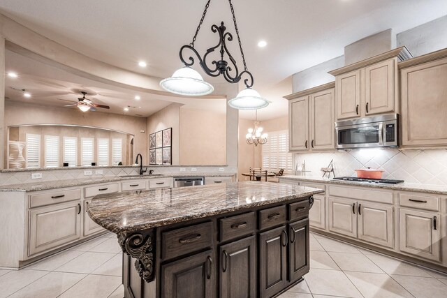 kitchen featuring light tile patterned flooring, a center island, a sink, backsplash, and stainless steel appliances