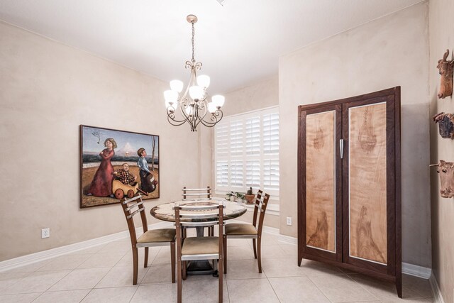 dining area with light tile patterned flooring, baseboards, and a chandelier
