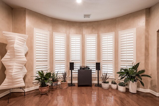 sitting room with baseboards, wood finished floors, and visible vents