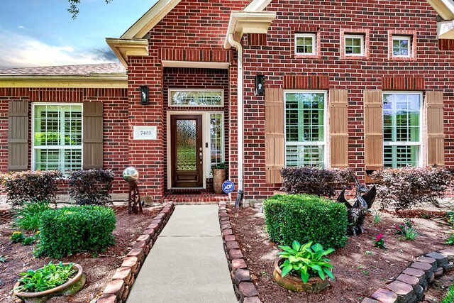 view of exterior entry featuring brick siding