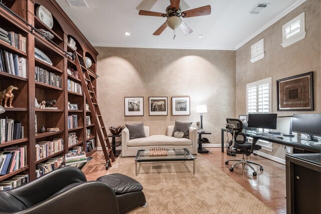 home office featuring a ceiling fan, baseboards, wood finished floors, visible vents, and ornamental molding
