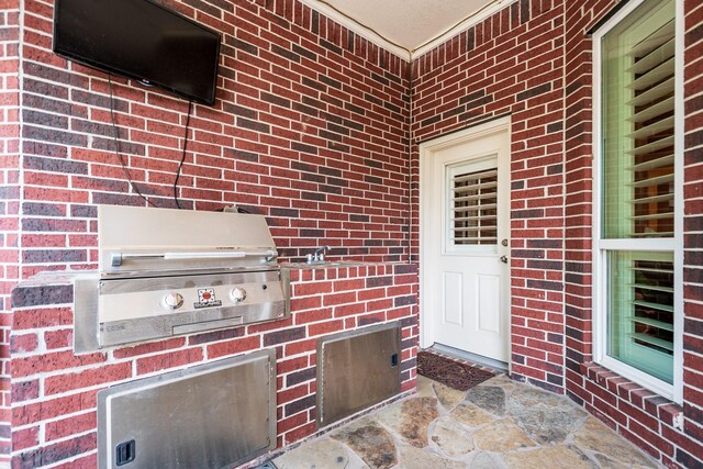 doorway to property with area for grilling and brick siding